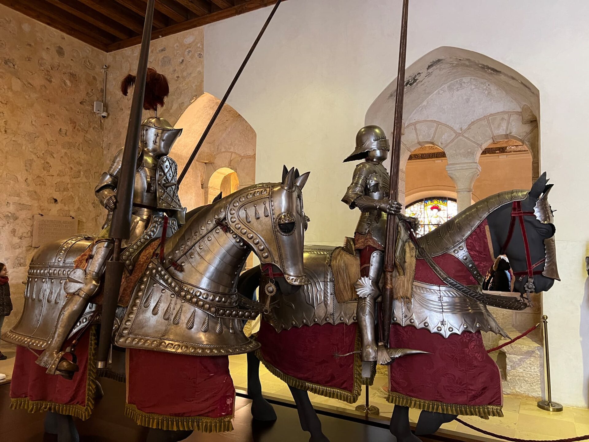 Medieval knights in armor on horseback display in museum.