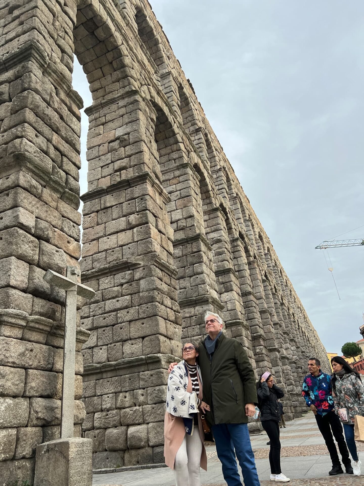 Couple posing by ancient Roman aqueduct.