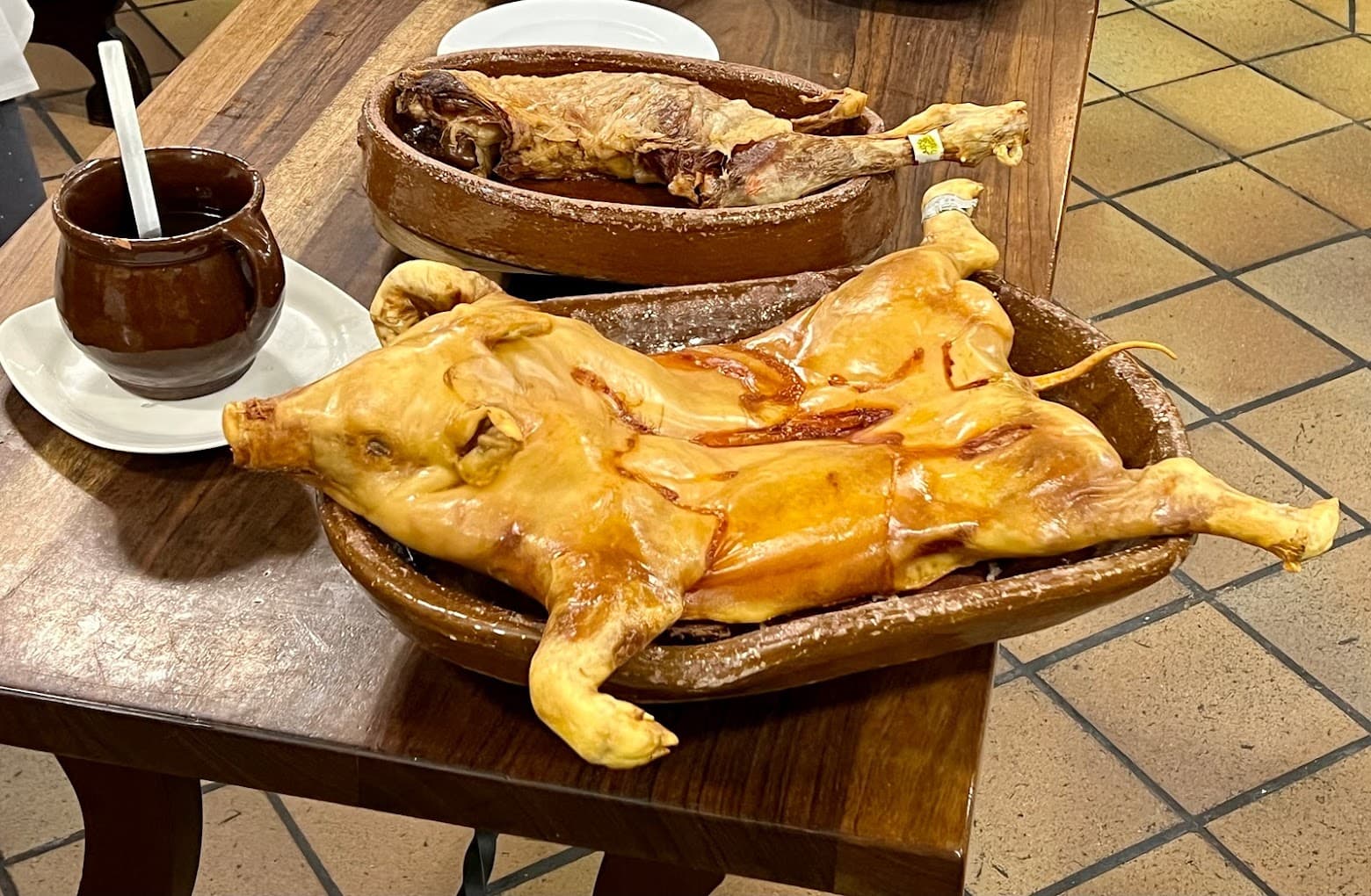 Roasted suckling pig on traditional clay dish.