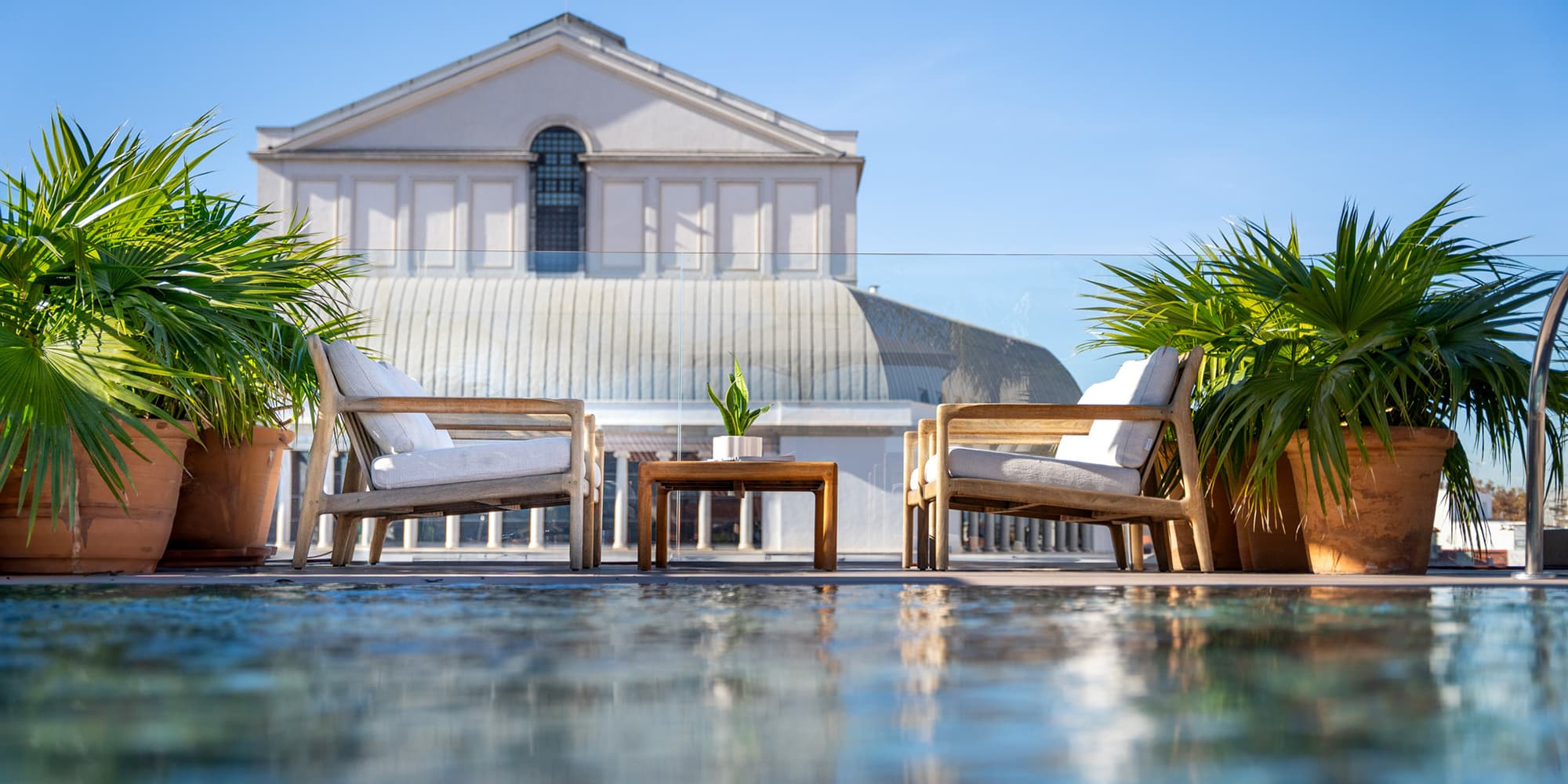 Ocean Drive Madrid luxurious rooftop terrace with neoclassical building backdrop.